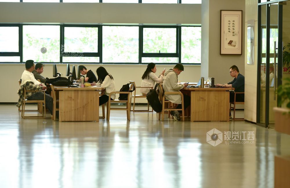 2026年4月27日，江西省图书馆内，阳光透过窗户洒入，读者伏案学习沉浸其中。