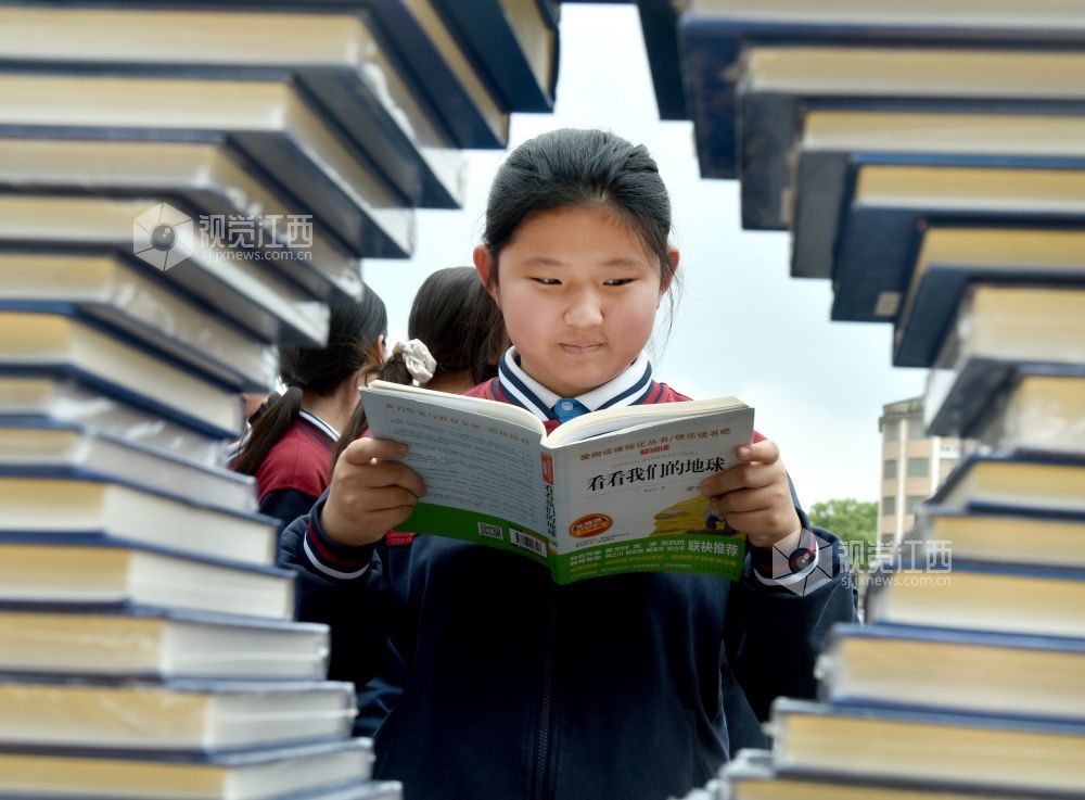 该校学生正在活动现场阅看自己喜欢的书籍。