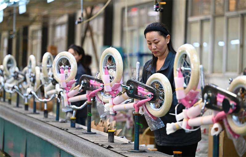 4月24日，平乡县河北萌兽儿童用品有限公司工人在童车生产线赶制出口订单。