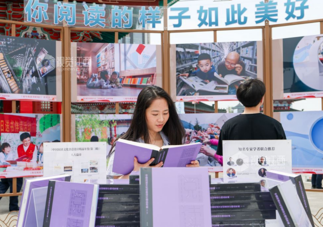 在第五届全民阅读大会活动之一的“书香满中国”公益宣传展展区,市民在阅读书籍。江西日报全媒体记者 田 野摄