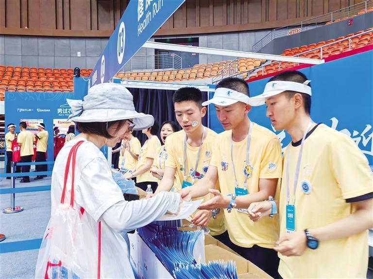 青年志愿者为参加兰州马拉松的选手发放参赛物品