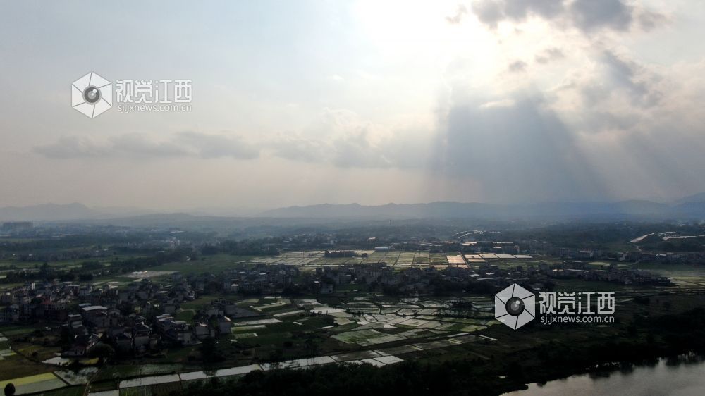 2026年5月6日，江西省遂川县泉江河畔，丁达尔光透过云层洒向大地，为河湾、稻田与错落民居镀上柔光，青山如黛，绿水含情，乡村田园风光如画，尽显生态之美与春日生机。