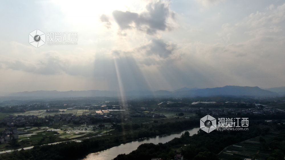 2026年5月6日，江西省遂川县泉江河畔，丁达尔光透过云层洒向大地，为河湾、稻田与错落民居镀上柔光，青山如黛，绿水含情，乡村田园风光如画，尽显生态之美与春日生机。