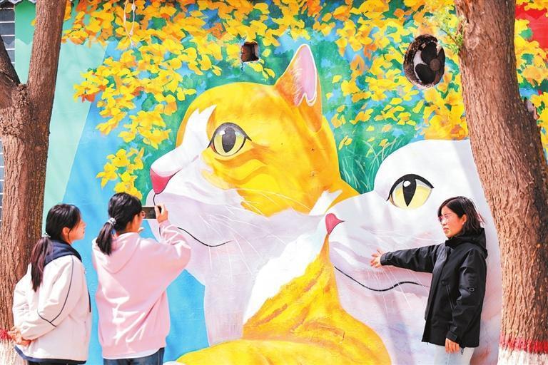 5月2日，游客在静宁县八里镇一处彩绘墙前拍照留念。新甘肃&middot;甘肃日报通讯员　侯崇慧