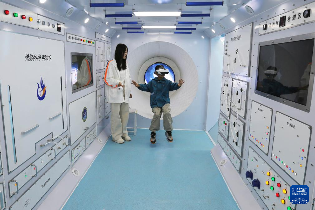 5月7日,学生在甘肃省定西市安定区人工智能教育基地体验VR遨游太空。新华社发(王克贤 摄)