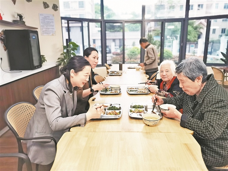 信州区民政局负责人（左一）在康伦养老机构陪餐。江西日报全媒体记者 陈 璋摄