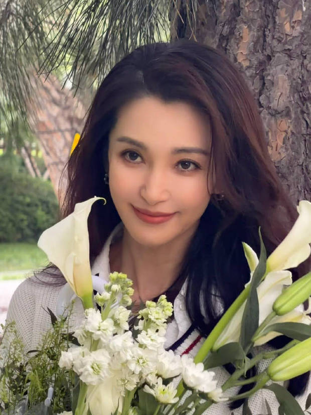 搜狐娱乐讯 近日，李冰冰现身品牌活动，身着简约白衬衫造型，手持百合漫步林间，生图美到到发光，气质优雅充满氛围感。
