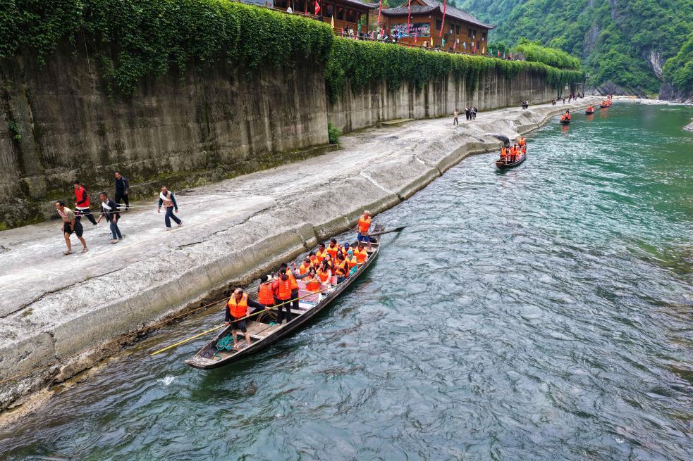 游客在湖北省巴东县神农溪纤夫文化旅游区体验人力拉纤。新华社发（焦国斌 摄）