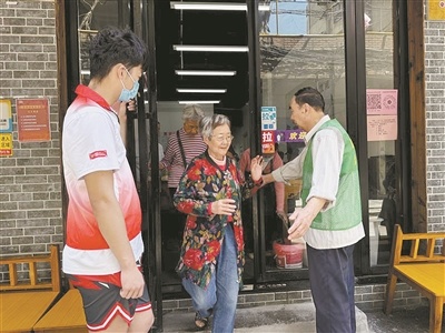 志愿者在食堂门口引导老人