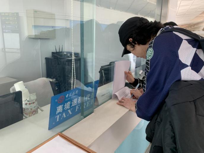图为境外旅客在中行退税点办理离境退税业务,童颜颜摄