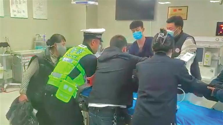 民警协助医护人员将伤者抬上急救推车