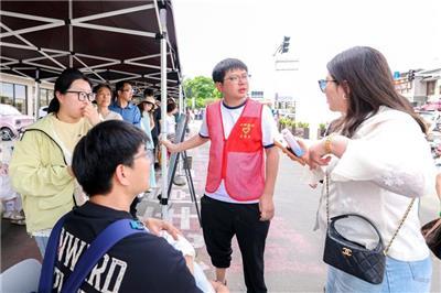 志愿者正维持三宝观光车排队秩序。 （袁涛 摄）