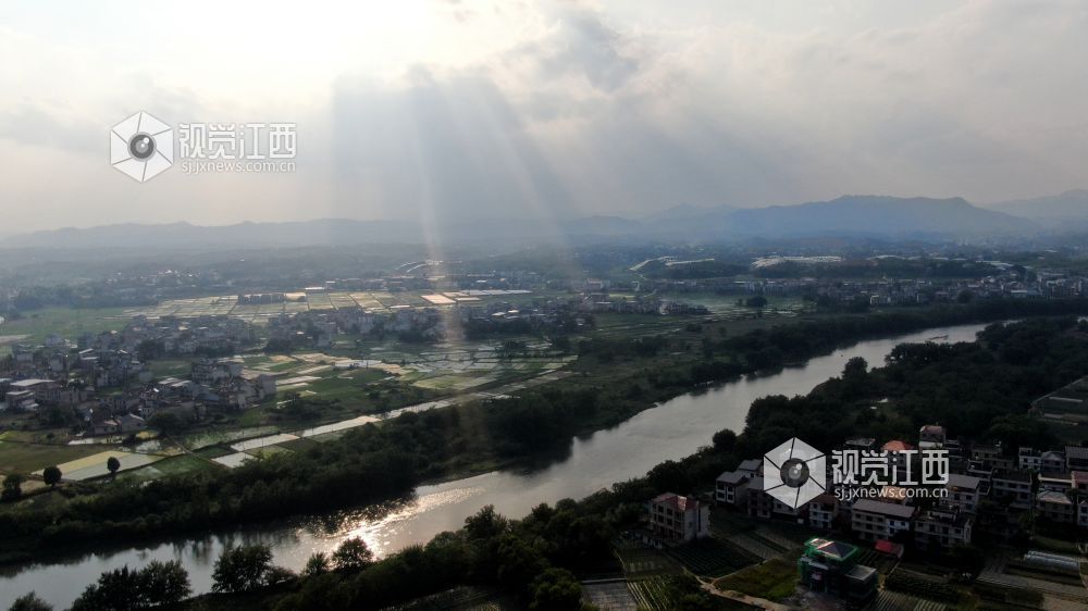 2026年5月6日，江西省遂川县泉江河畔，丁达尔光透过云层洒向大地，为河湾、稻田与错落民居镀上柔光，青山如黛，绿水含情，乡村田园风光如画，尽显生态之美与春日生机。