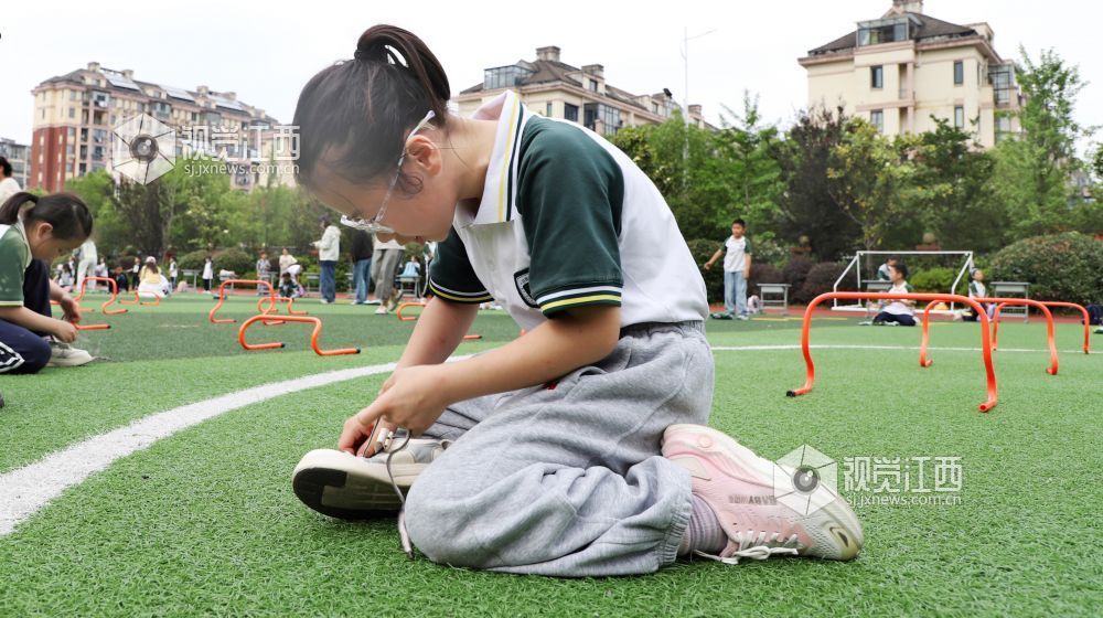 5月14日，江西省新余市渝水区城北街道北湖小学的学生在进行穿鞋带比赛。