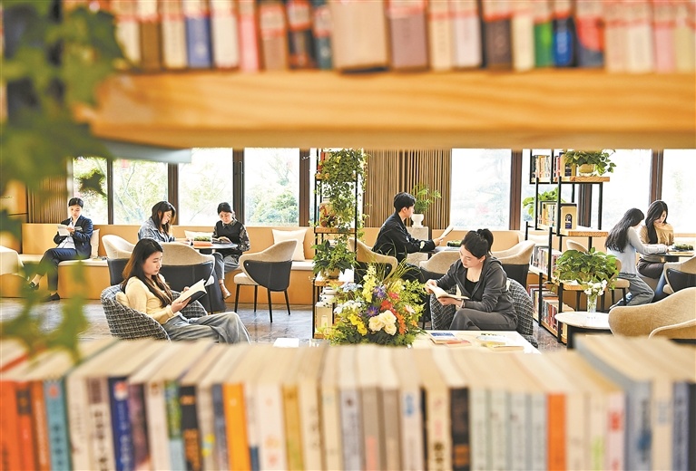 在万载县康乐街道西门社区山和樾城市书房，人们正专心阅读。在快节奏的生活中，静心阅读成了许多人触手可及的“诗与远方”。通讯员 周 亮摄