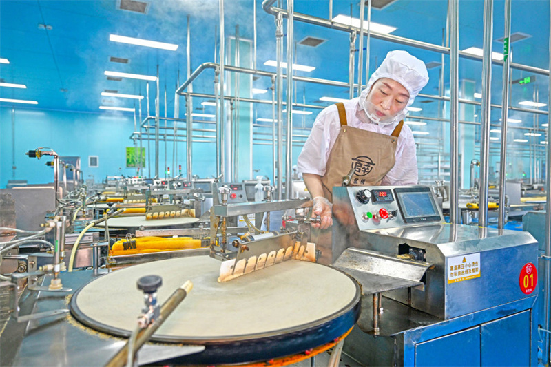 5月8日，工人在位于盐山县薛堂村的河北薛堂情食品有限公司煎饼加工车间忙碌。