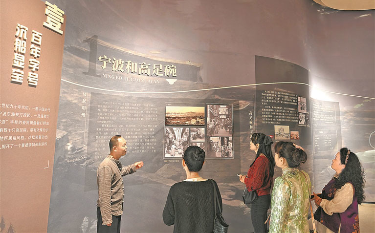 馆长罗文波在博物馆“百年字号 沉船显宝”主题展区，为游客介绍高足碗。