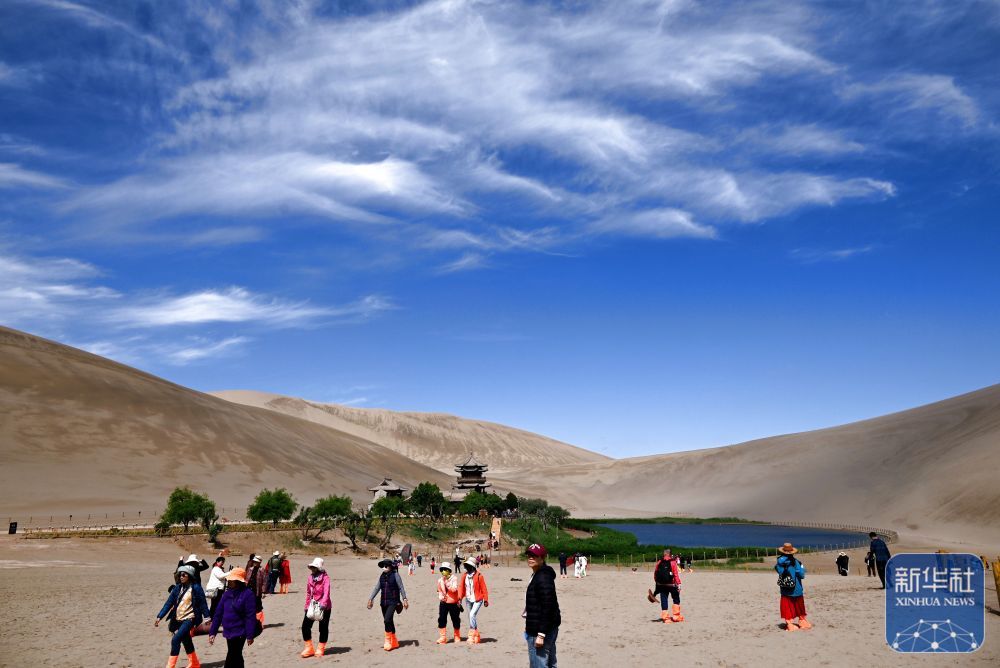 5月14日，游客在甘肃省敦煌市鸣沙山月牙泉景区游览赏景。新华社发（张晓亮　摄）