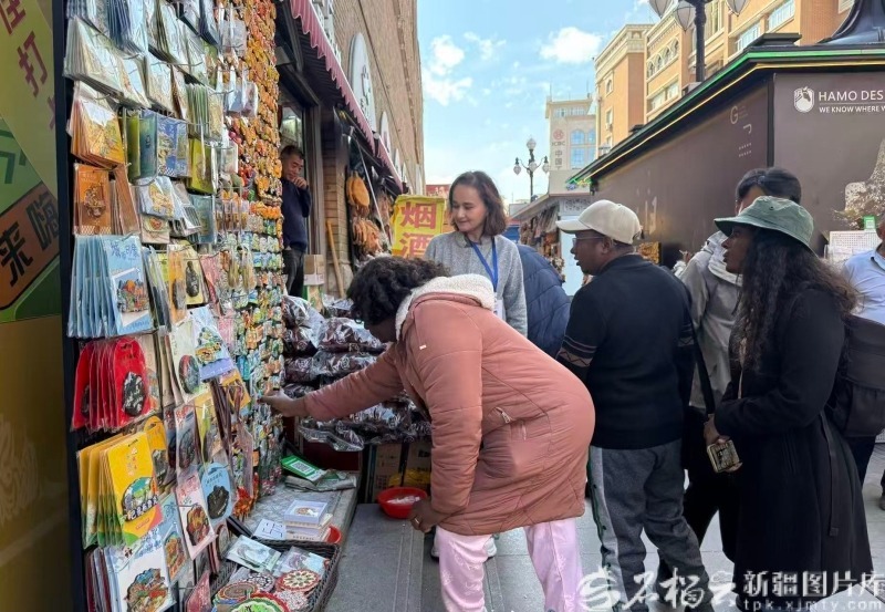 5月13日,几内亚比绍国家电视台台长莫尼卡·布阿罗·达科斯塔在新疆国际大巴扎翻看特色文创产品。石榴云/新疆日报记者 司路路摄