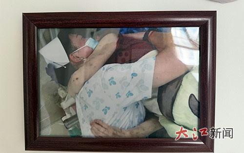 一张患者抱着谢丽萍的照片被裱进相框里珍藏。