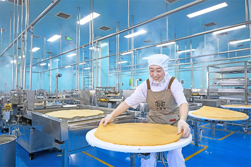 5月8日，工人在位于盐山县薛堂村的河北薛堂情食品有限公司煎饼加工车间忙碌。