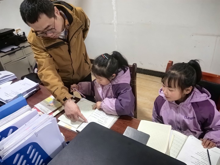 兰州石化职业技术大学能源与动力工程学院副院长沈霁坚持为结对关爱的两姐妹辅导功课　甘肃省民政厅供图