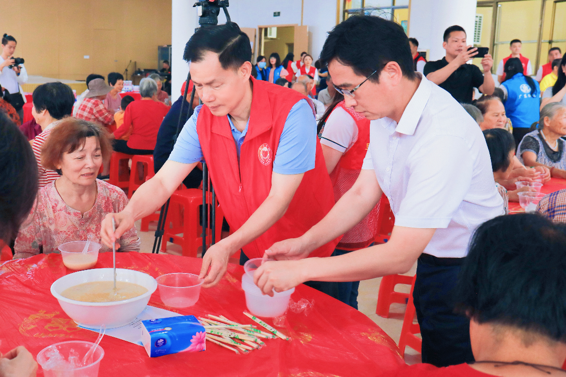 图:志愿者为村内老人盛粥递餐