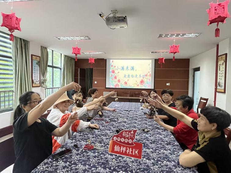 图为居民们展示制作完成的果壳摇铃