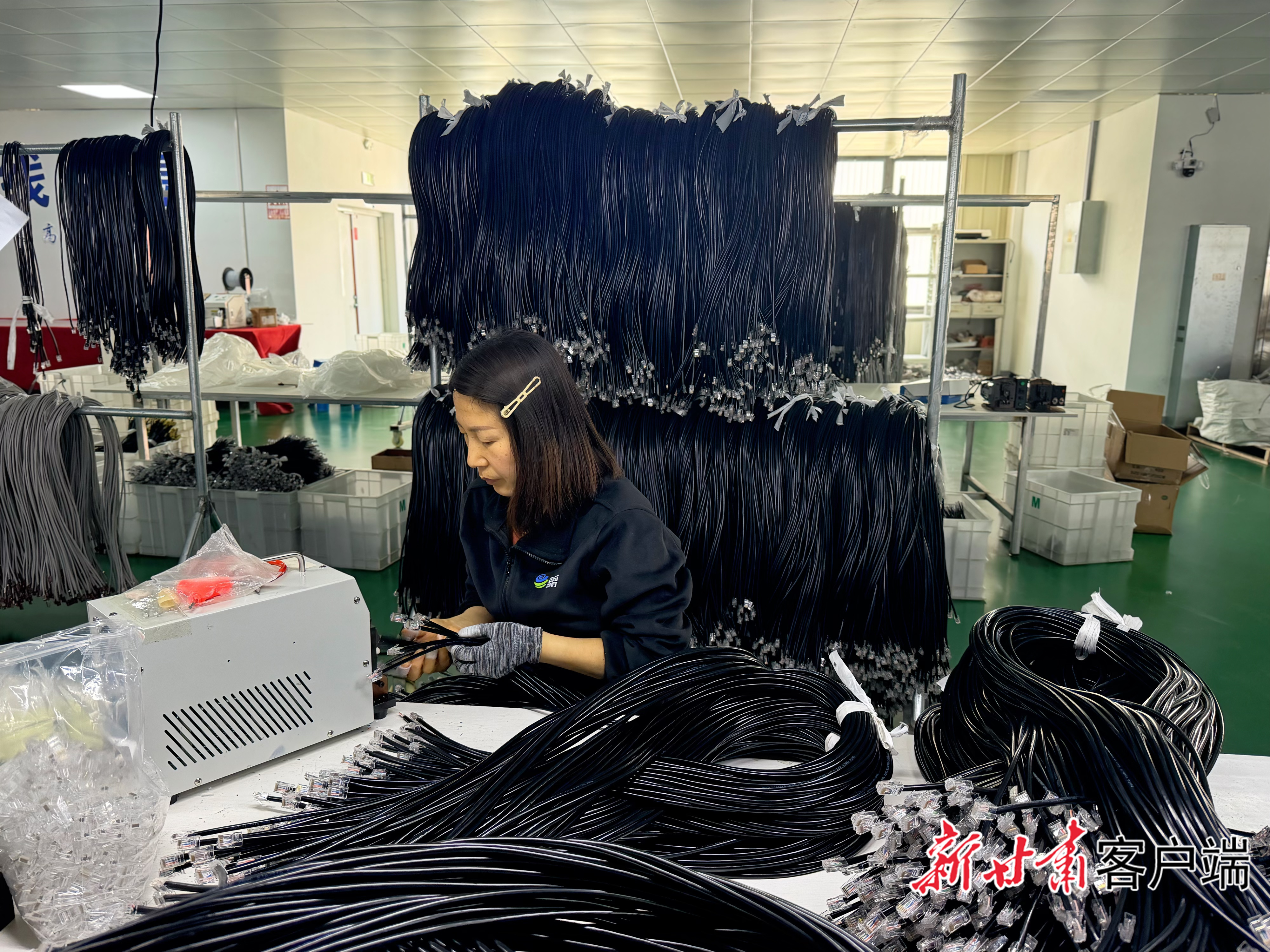 车间内,工人进行线缆水晶头加工作业。