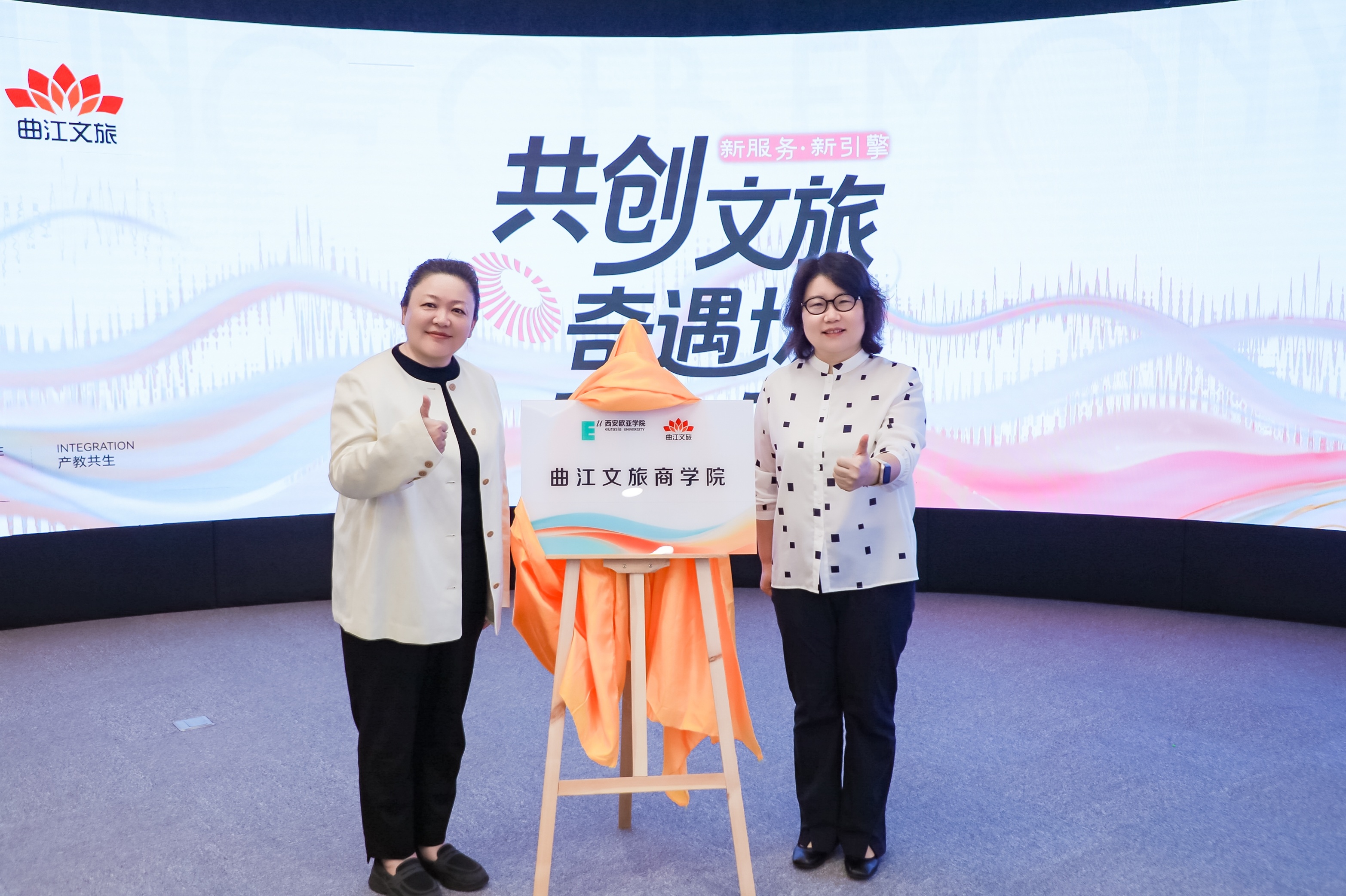 西安欧亚学院副校长王艳（右）与曲江文旅党委书记、董事长庄莹共同为曲江文旅商学院揭牌