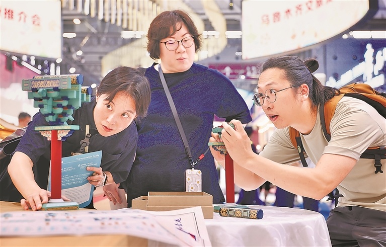 第二十二届深圳文博会江西馆看点十足，陶瓷、錾刻、木雕、数智、文创等展品受到现场展商、市民和游客青睐。图为5月22日，在深圳国际会展中心江西馆展区，游客体验计时拼接故宫保和殿榫卯积木，感受中国古建筑的魅力。本报全媒体记者 徐 铮摄