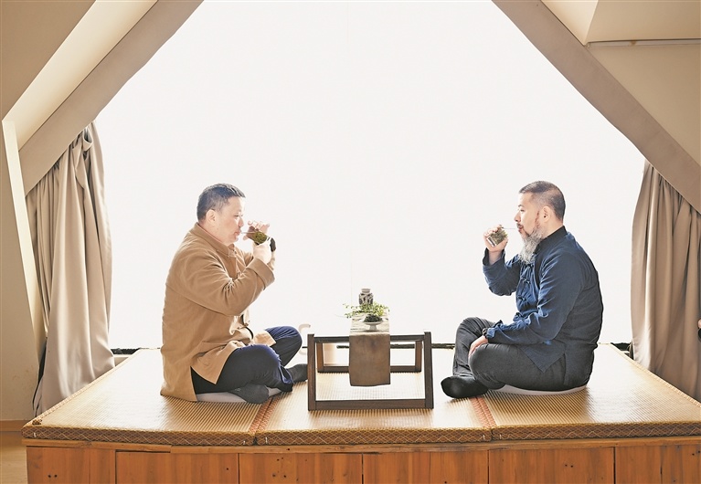 4月23日，庐山风景区小天池附近一家民宿里，民宿主理人胡武昌（左）和记者在品味庐山云雾茶。