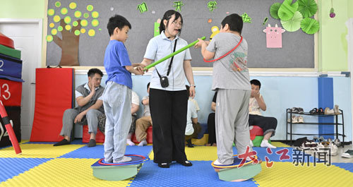 教师指导孩子做针对身体平衡的训练。本文配图由信息日报全媒体记者王祺摄