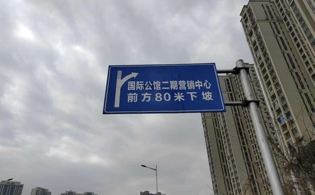 涉事小区附近主干道旁立的指示牌。