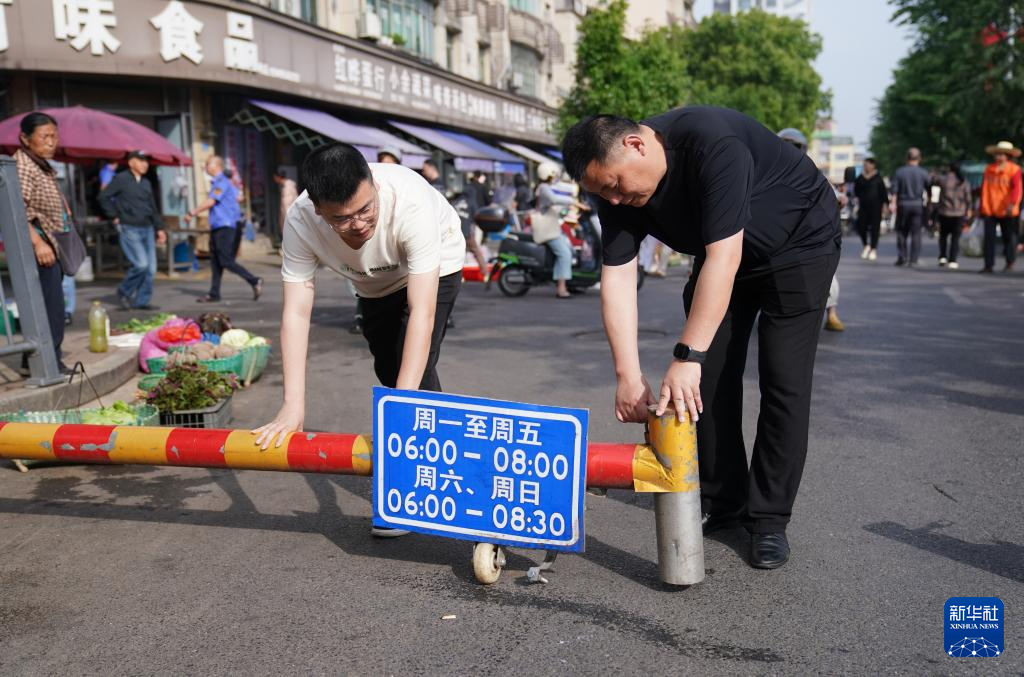 早上8点，“潮汐菜场”管理人员将栏杆移除，恢复道路正常通行（5月12日摄）。