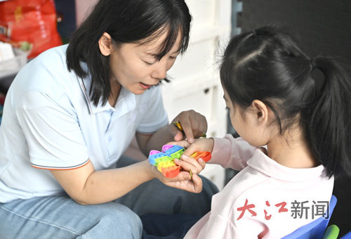 教师通过色彩鲜艳的教学器具吸引孩子的注意力