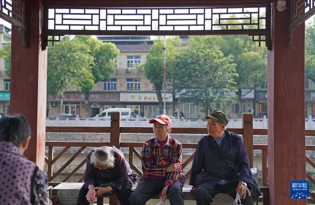 几名买菜的老人在“潮汐菜场”边的凉亭休息（5月12日摄）。