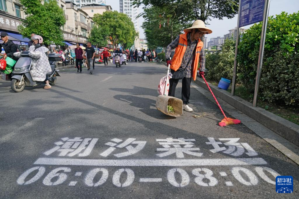 早上8点，环卫工人（右一）正在清理街道，恢复道路正常通行（5月12日摄）。