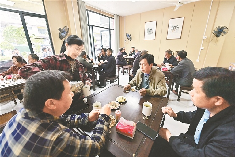 5月10日，在遂川县汤湖镇茶人梁奇美经营的一家茶铺，赶圩的乡亲们围坐在一起喝茶聊天。