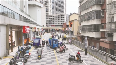 贵溪市天虹商圈东北进出口,各类非机动车在此停放,人流、车流混行。
