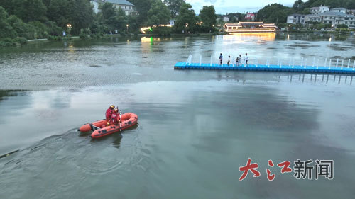 消防救援人员驾驶橡皮艇靠近浮桥。