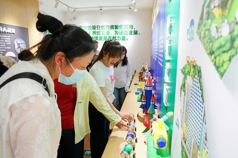 图说:垃圾废物利用做的工艺品吸引市民观看。