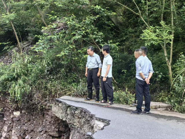 （工作组在X008路基冲毁现场研判抢通方案。）
