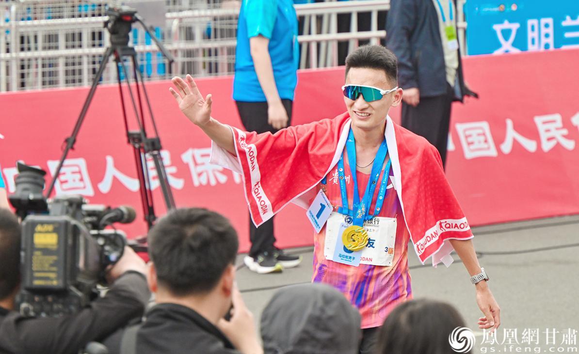 全程马拉松男子组中国籍冠军丰配友完赛后与场边加油的观众热情互动