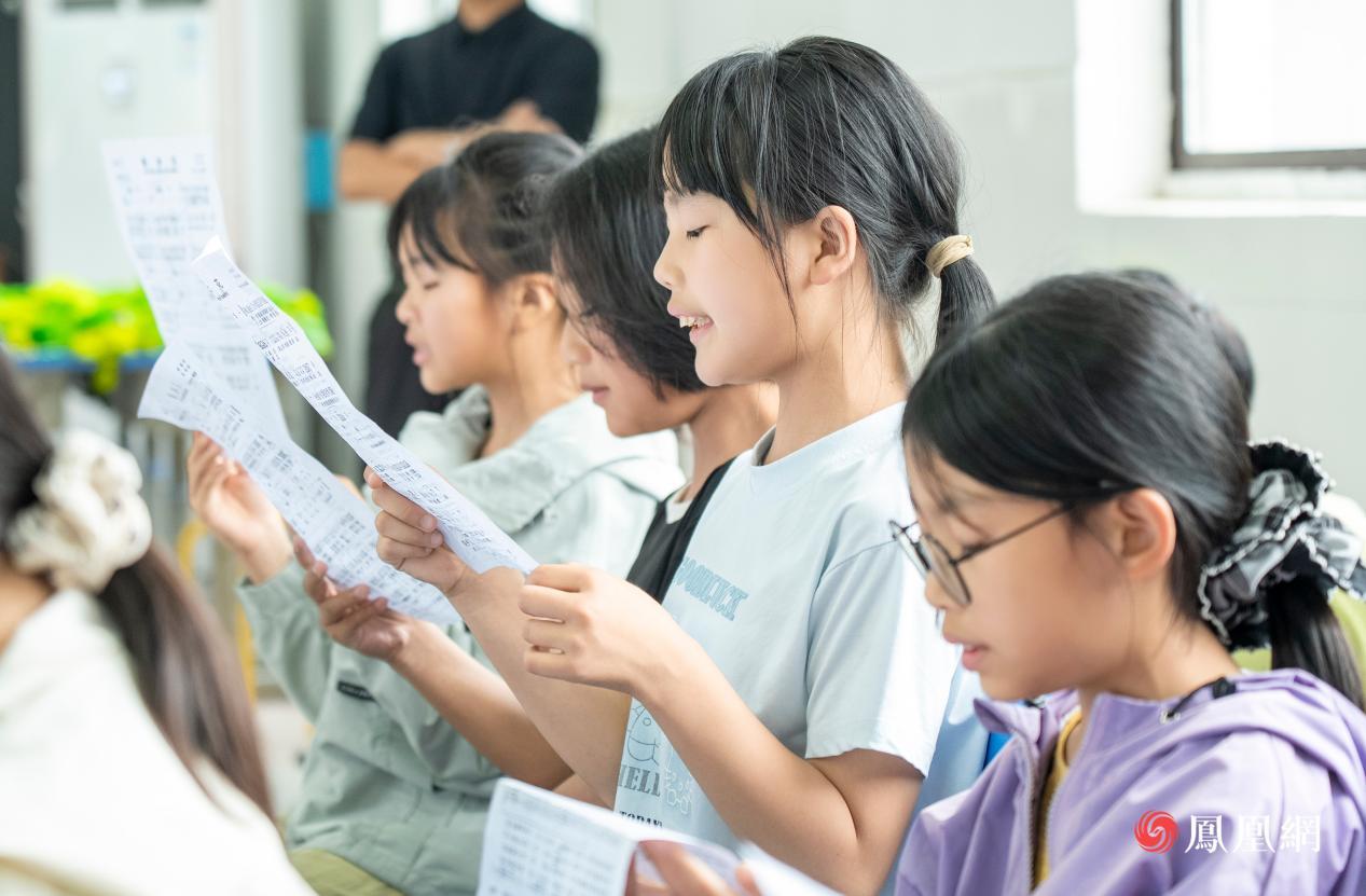 孩子们在认真的跟随钢琴伴奏学唱歌曲
