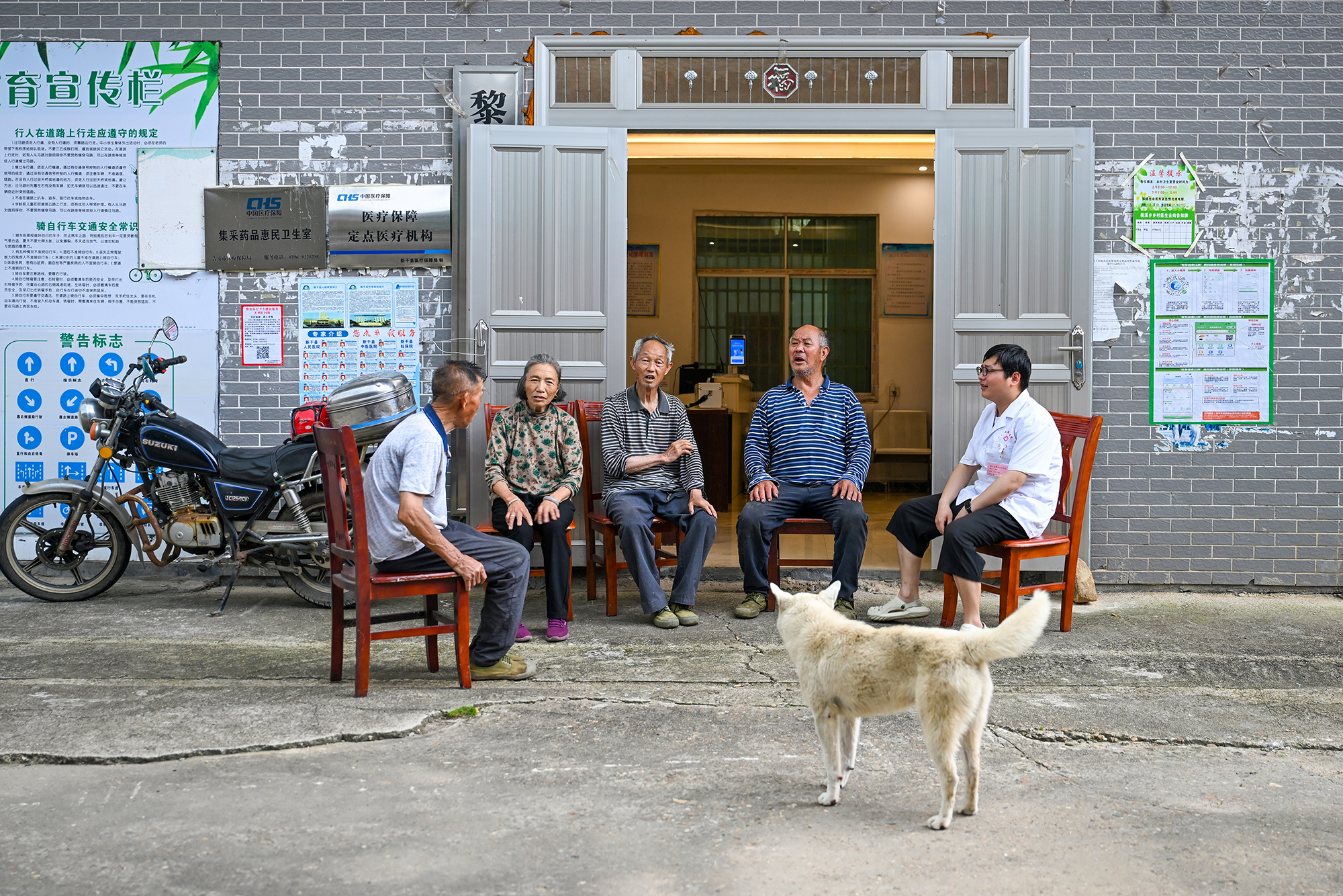 ▲村卫生室也成了老人们日常闲谈休憩的场所，他在问诊之余，时常陪伴老人聊天。