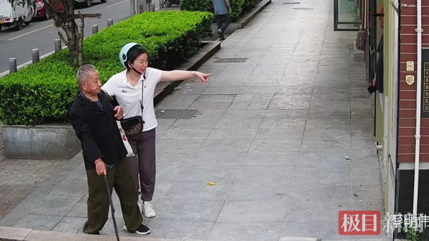 戴头盔女子将老人扶到路边休息