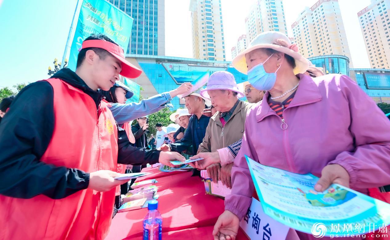 环保志愿者向公众发放宣传资料，普及绿色低碳知识。