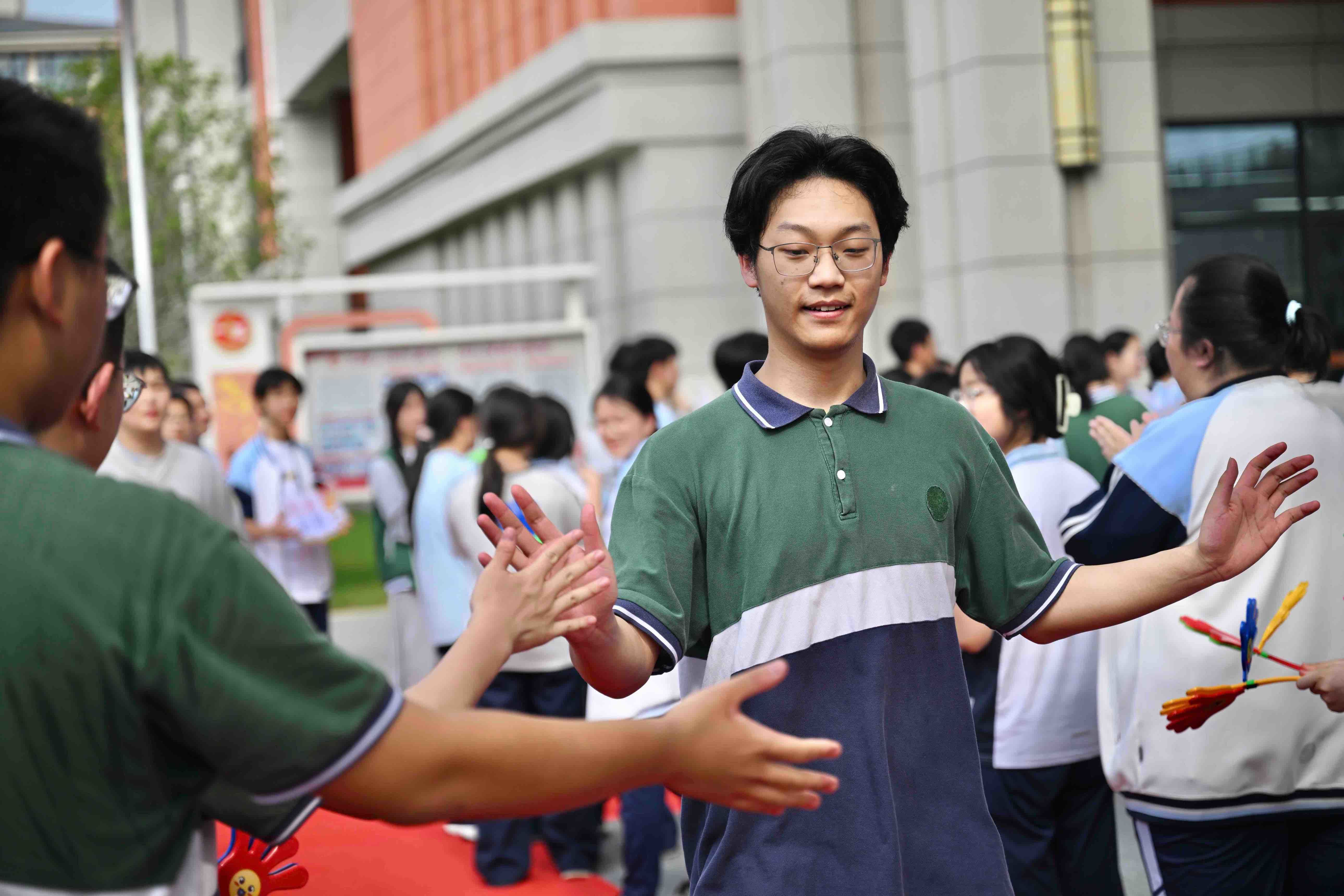 与考生击掌打气。摄影｜江西日报全媒体记者蔡铖歌