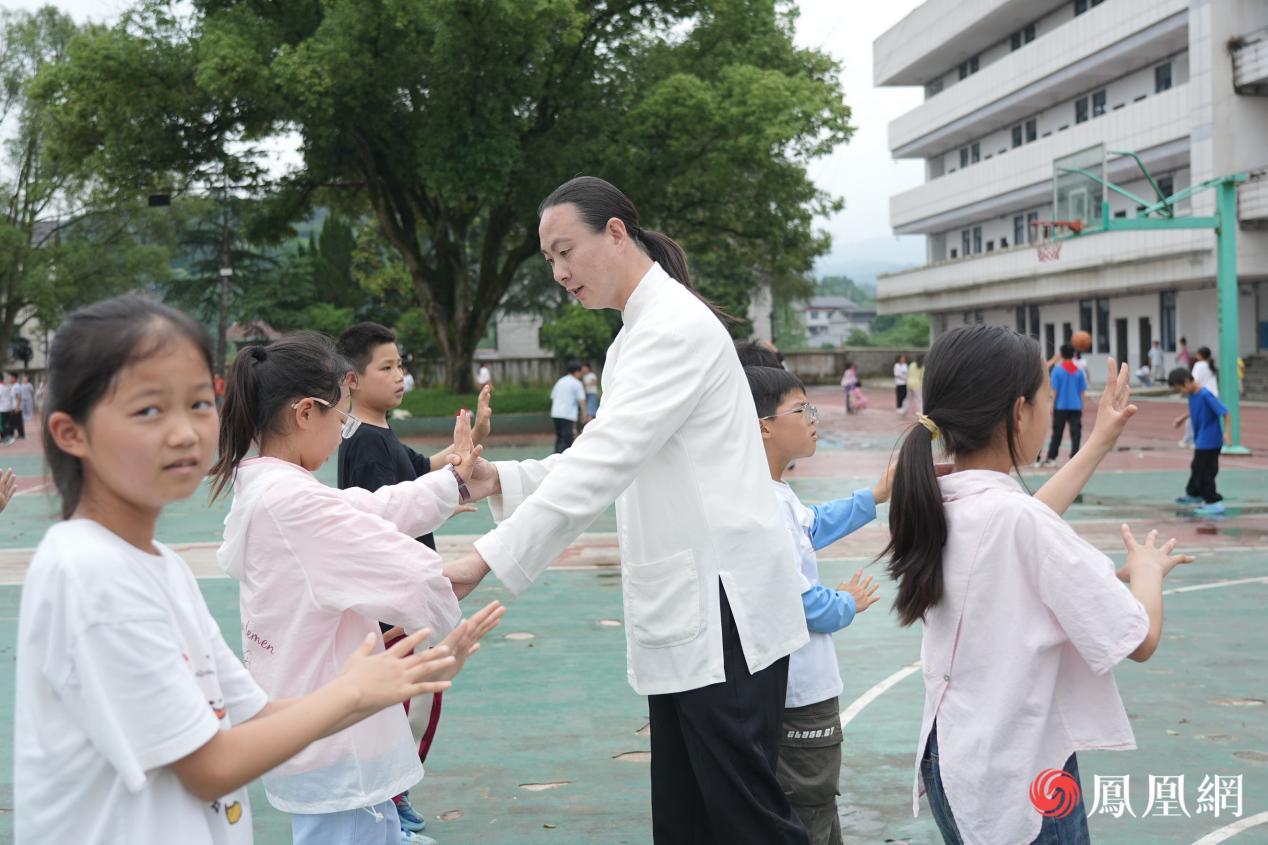 志愿者王明山正在为孩子们指导动作